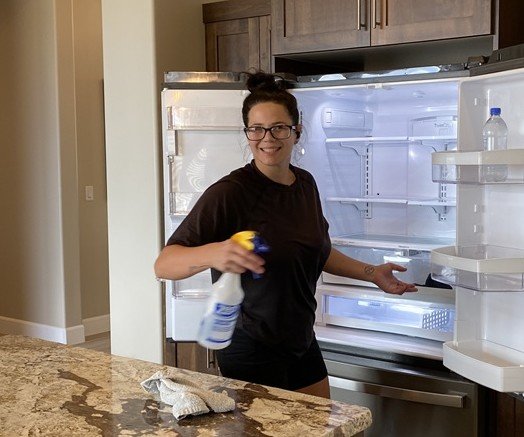 A picture of our head house cleaner Krisandra, cleaning a fridge. 